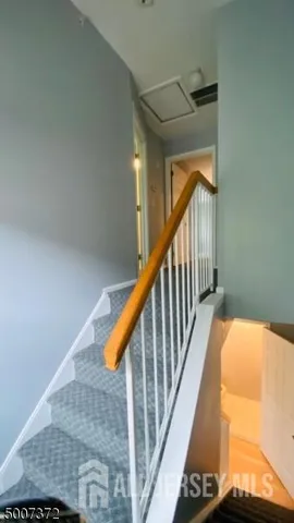a view of staircase with railing and wooden floor