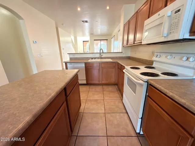 a large kitchen with stainless steel appliances granite countertop a stove a sink a counter space and cabinets