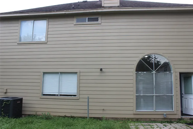 a view of backyard with wooden fence and large trees