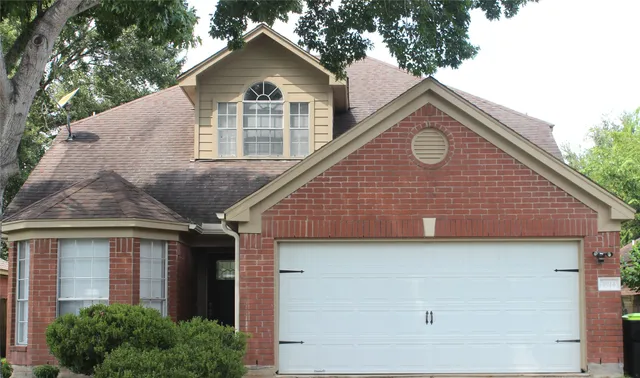 a front view of a house with yard and trees