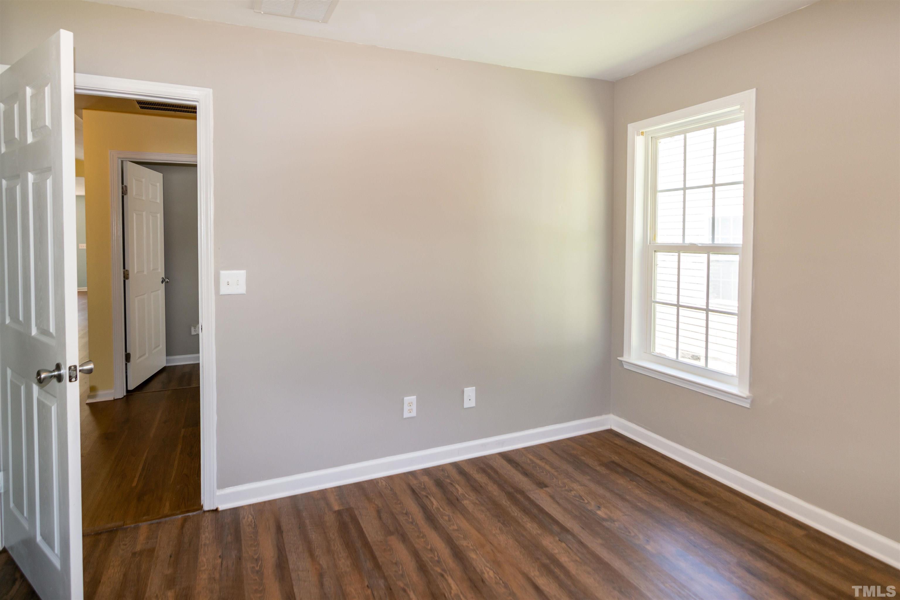 1127 Ricochet Drive Raleigh, NC 27610 - Photo 19 of 21 an empty room with wooden floor and a window