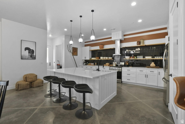 4346 Canterbury Road Hurricane, UT 84737 - Photo 5 of 37 Kitchen featuring white cabinetry, finished concrete flooring, stainless steel appliances, and a kitchen island with sink