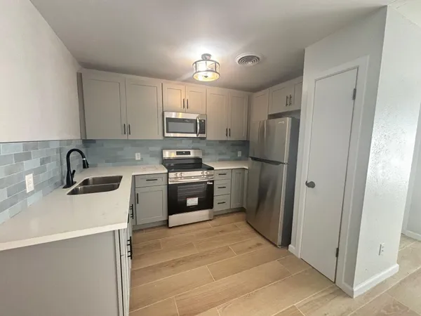 a kitchen with stainless steel appliances a refrigerator sink and cabinets