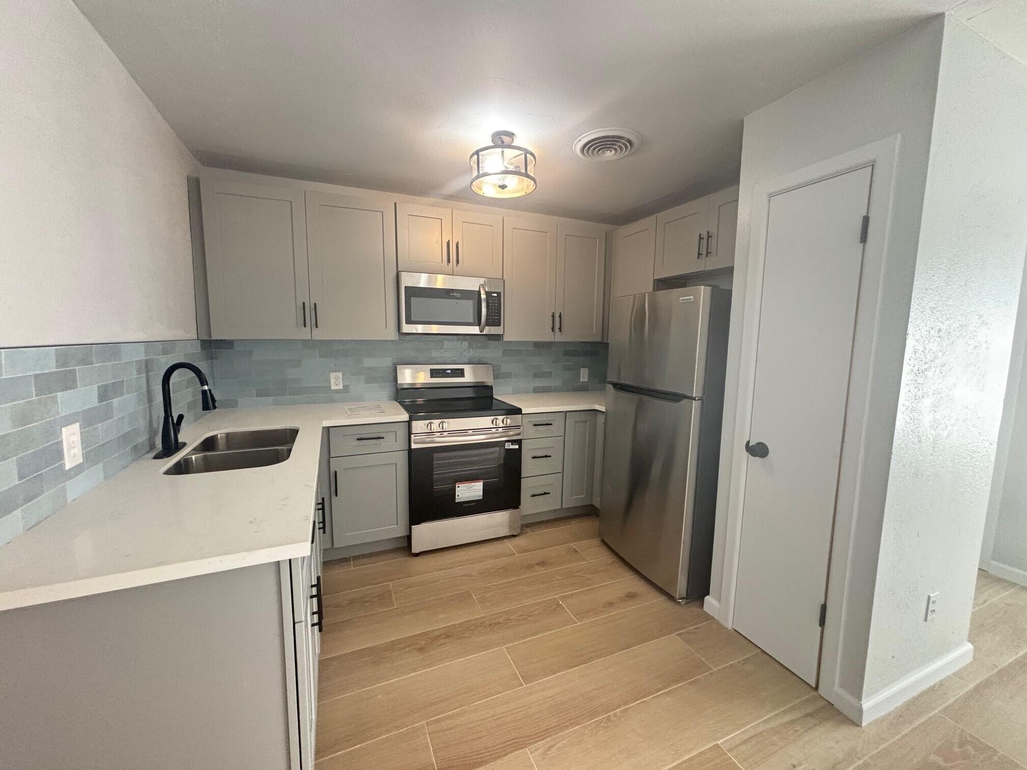 2409 45th Street, Unit 8 Lubbock, TX 79412 - Photo 2 of 8 a kitchen with stainless steel appliances a refrigerator sink and cabinets