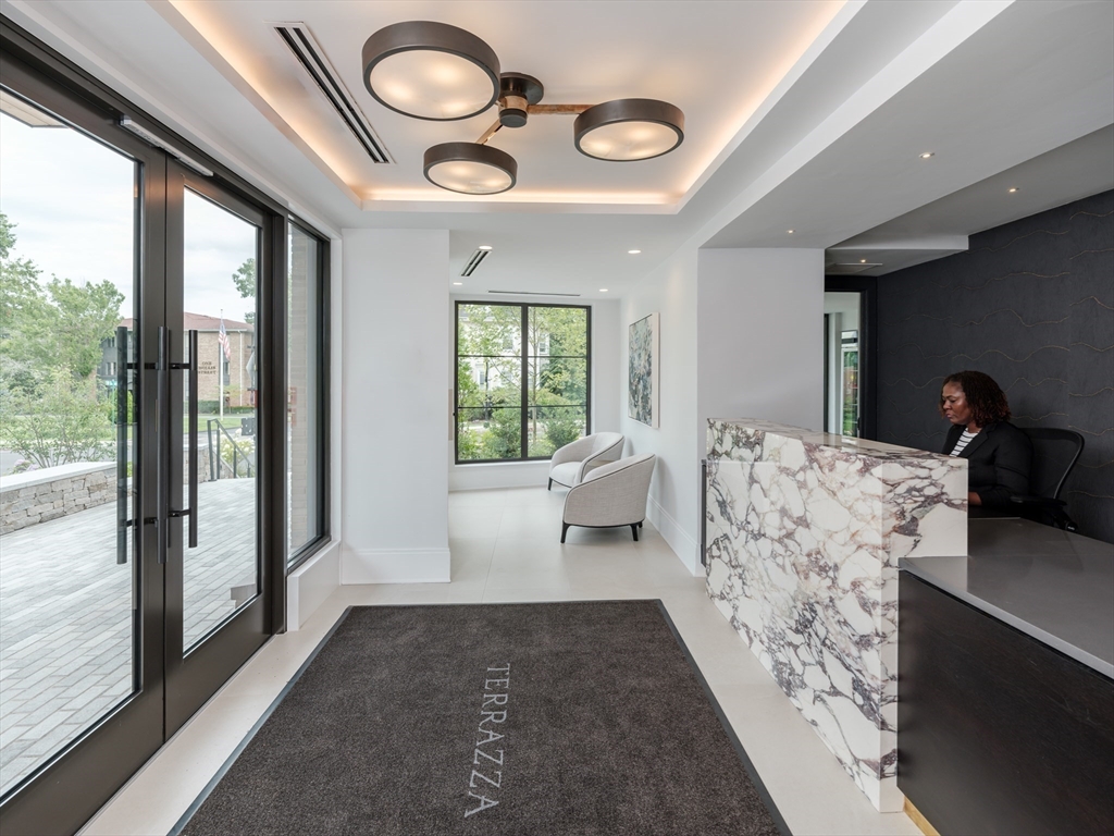 100 Linden Street, Unit 103 Wellesley, MA 02482 - Photo 14 of 30 a living room with furniture and a large window