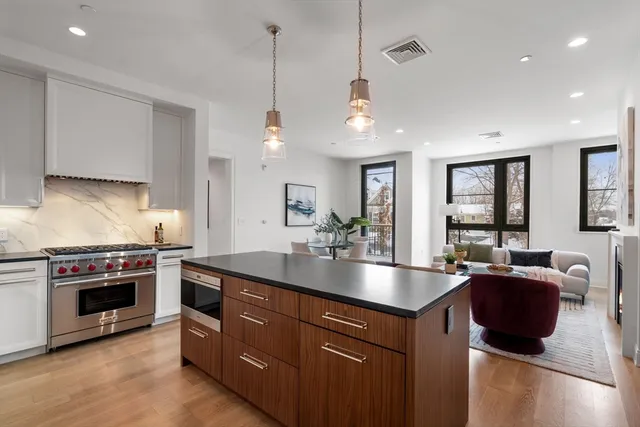 a kitchen with kitchen island granite countertop a stove and a sink