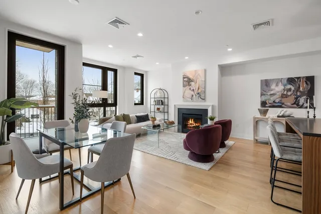 a living room with furniture a fireplace and a large window