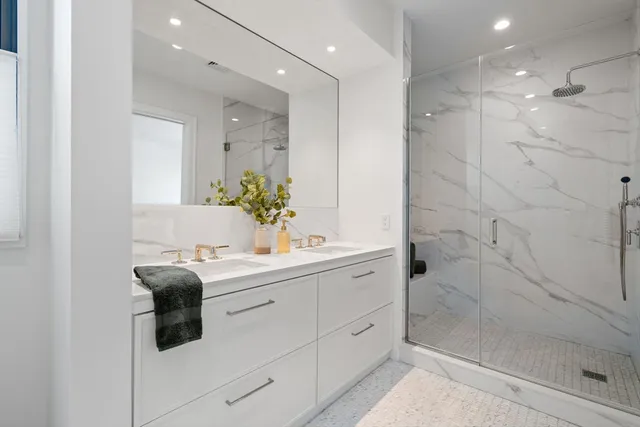 a bathroom with a sink mirror and shower