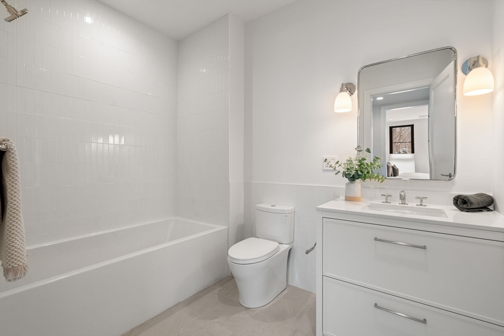 100 Linden Street, Unit 103 Wellesley, MA 02482 - Photo 9 of 30 a bathroom with a sink a toilet and shower
