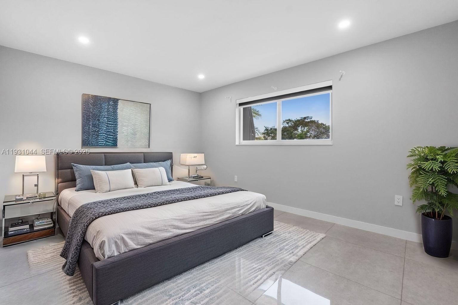 8443 Southwest 137th Avenue, Unit 8443 Miami, FL 33183 - Photo 22 of 29 a spacious bedroom with a large bed and a potted plant