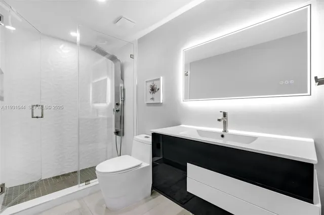 a bathroom with a sink a toilet and shower