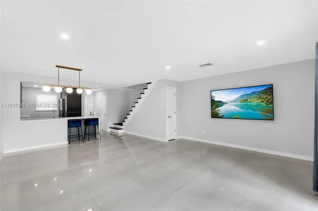 an empty room with furniture and a flat screen tv