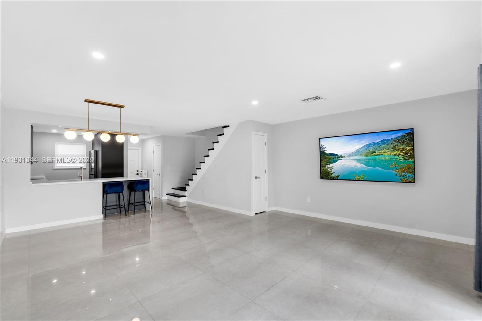 8443 Southwest 137th Avenue, Unit 8443 Miami, FL 33183 - Photo 7 of 29 an empty room with furniture and a flat screen tv