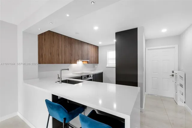 a kitchen with stainless steel appliances a sink a stove a refrigerator and cabinets