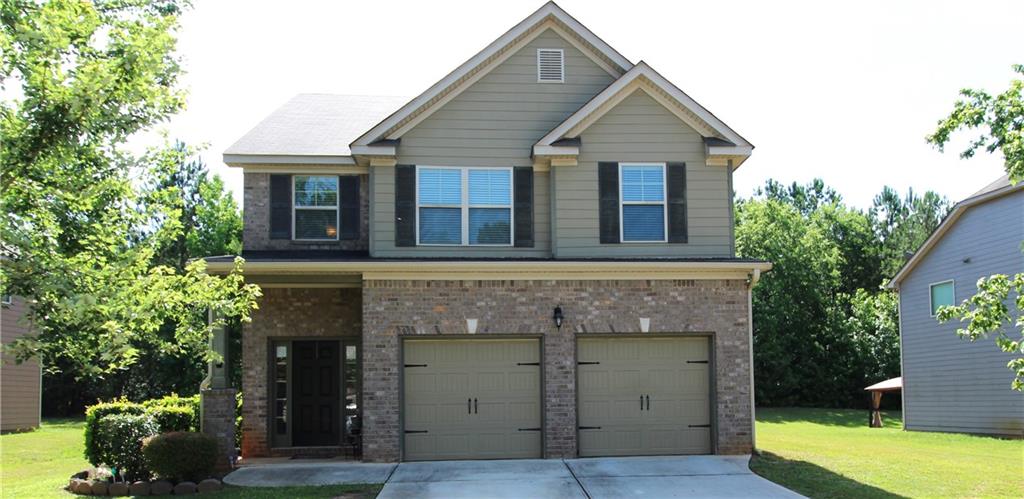 1422 Stone Ridge Court Hampton, GA 30228 - Photo 1 of 1 a front view of a house with a garden and plants