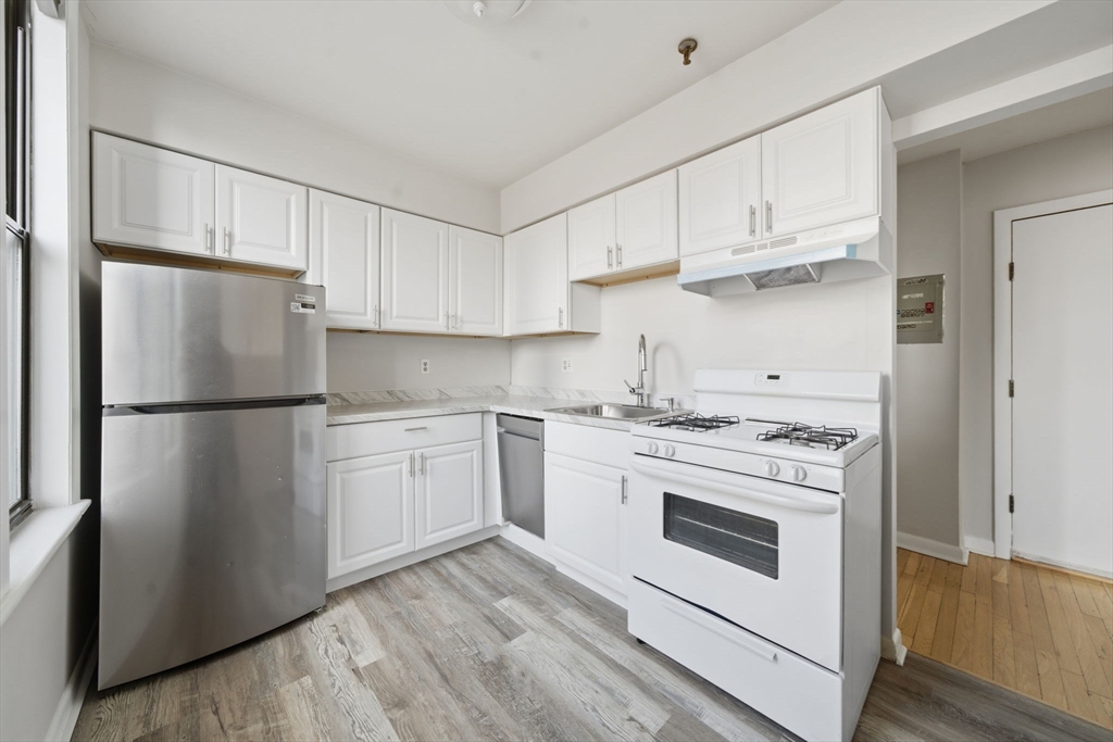 1480 Commonwealth Avenue, Unit 10 Boston, MA 02135 - Photo 2 of 19 a kitchen with white cabinets and white appliances