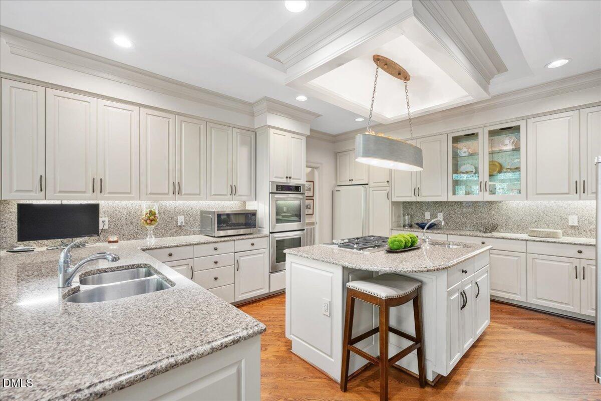 512 Hertford Street Raleigh, NC 27609 - Photo 11 of 39 a kitchen with a stove a sink a kitchen island with a dining table and chairs