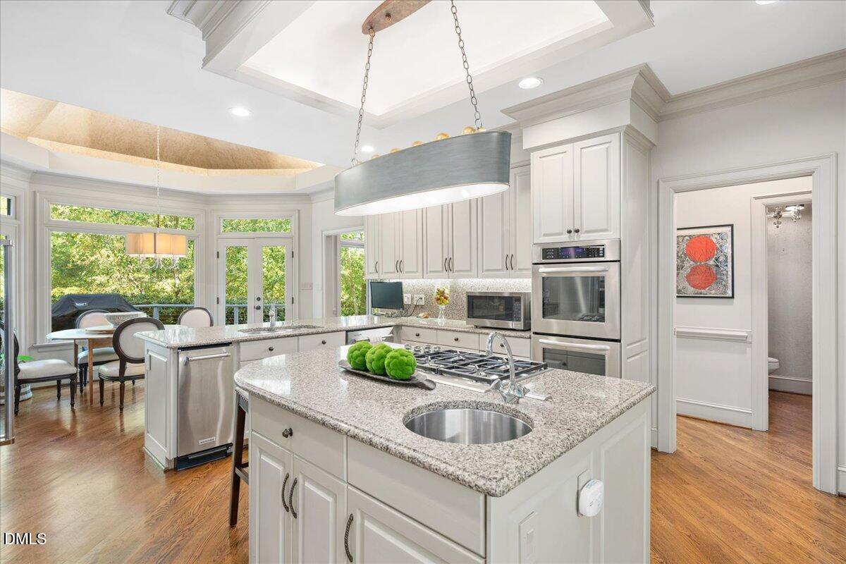 512 Hertford Street Raleigh, NC 27609 - Photo 12 of 39 a kitchen with kitchen island granite countertop a sink and center island
