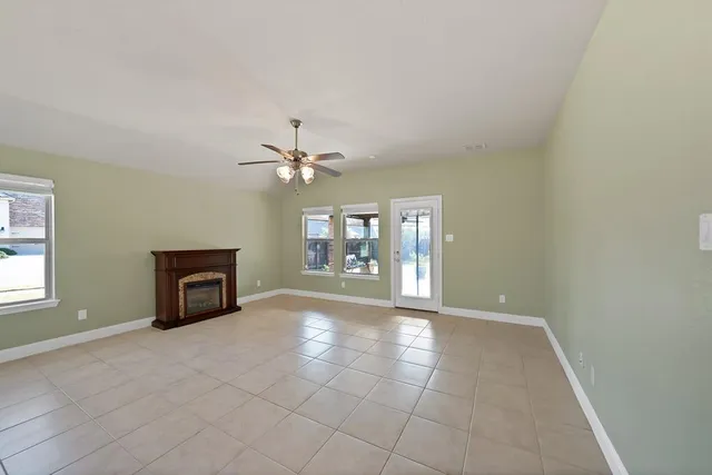 an empty room with windows and fireplace