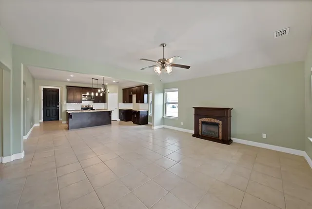 a view of a livingroom with a fireplace and a ceiling fan