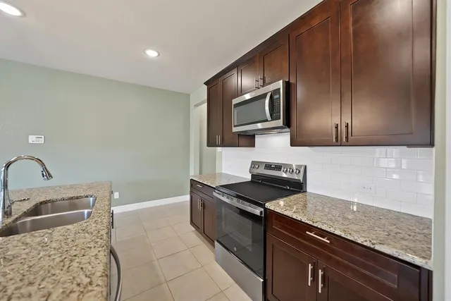 a kitchen that has a sink and a stove top oven