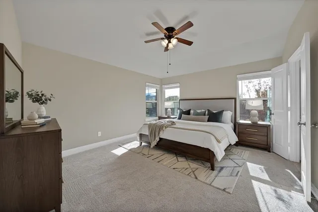 a bed sitting in a bedroom next to a window and a chandelier