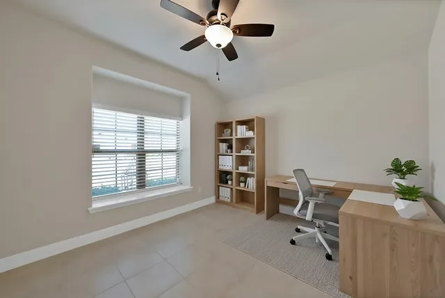 a view of a workspace with furniture and a window