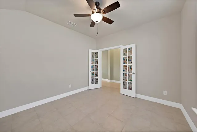en empty room with closet and a ceiling fan