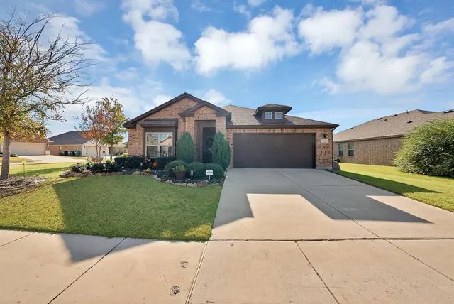a front view of a house with a yard and trees