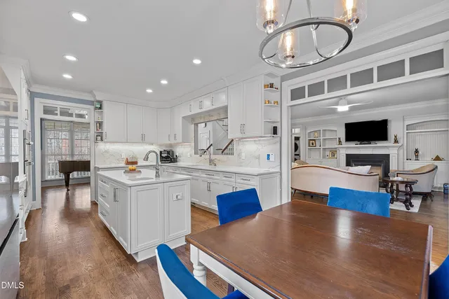 a dining room with furniture a chandelier and wooden floor