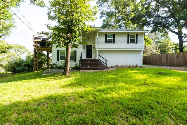 a front view of house with yard and trees