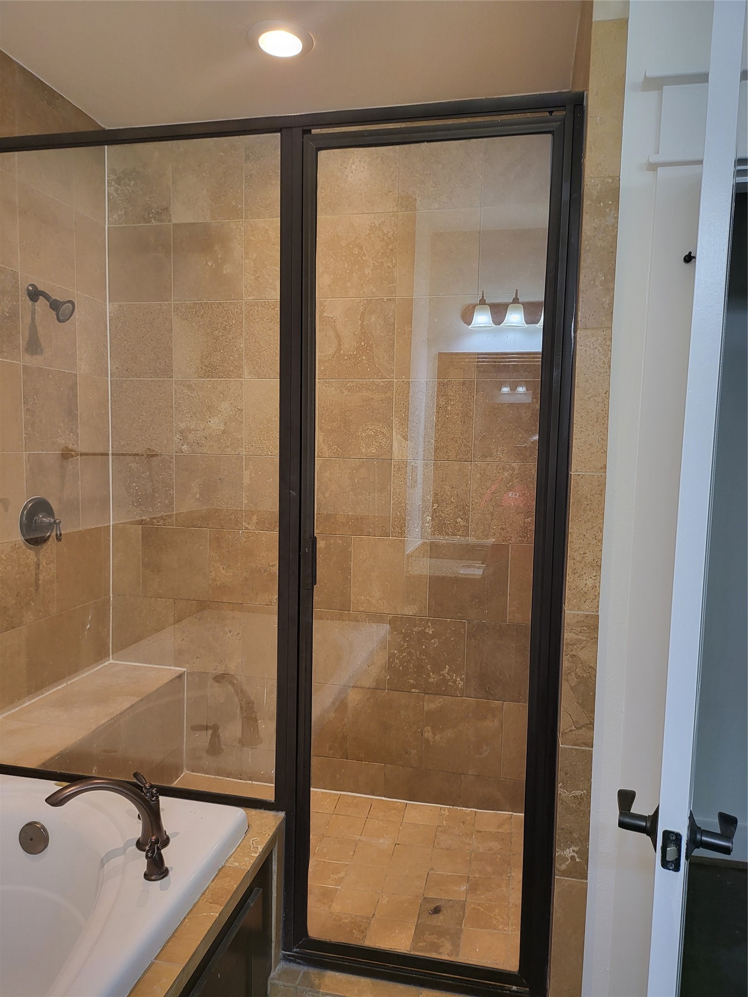 2423 Roufa Road Houston, TX 77003 - Photo 8 of 22 The primary bathroom includes an oversized shower with a seat and a heating lamp.