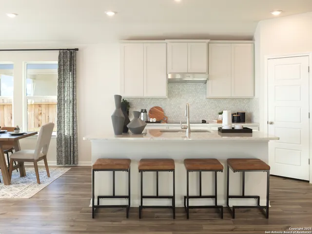 a kitchen with a table chairs stove and cabinets