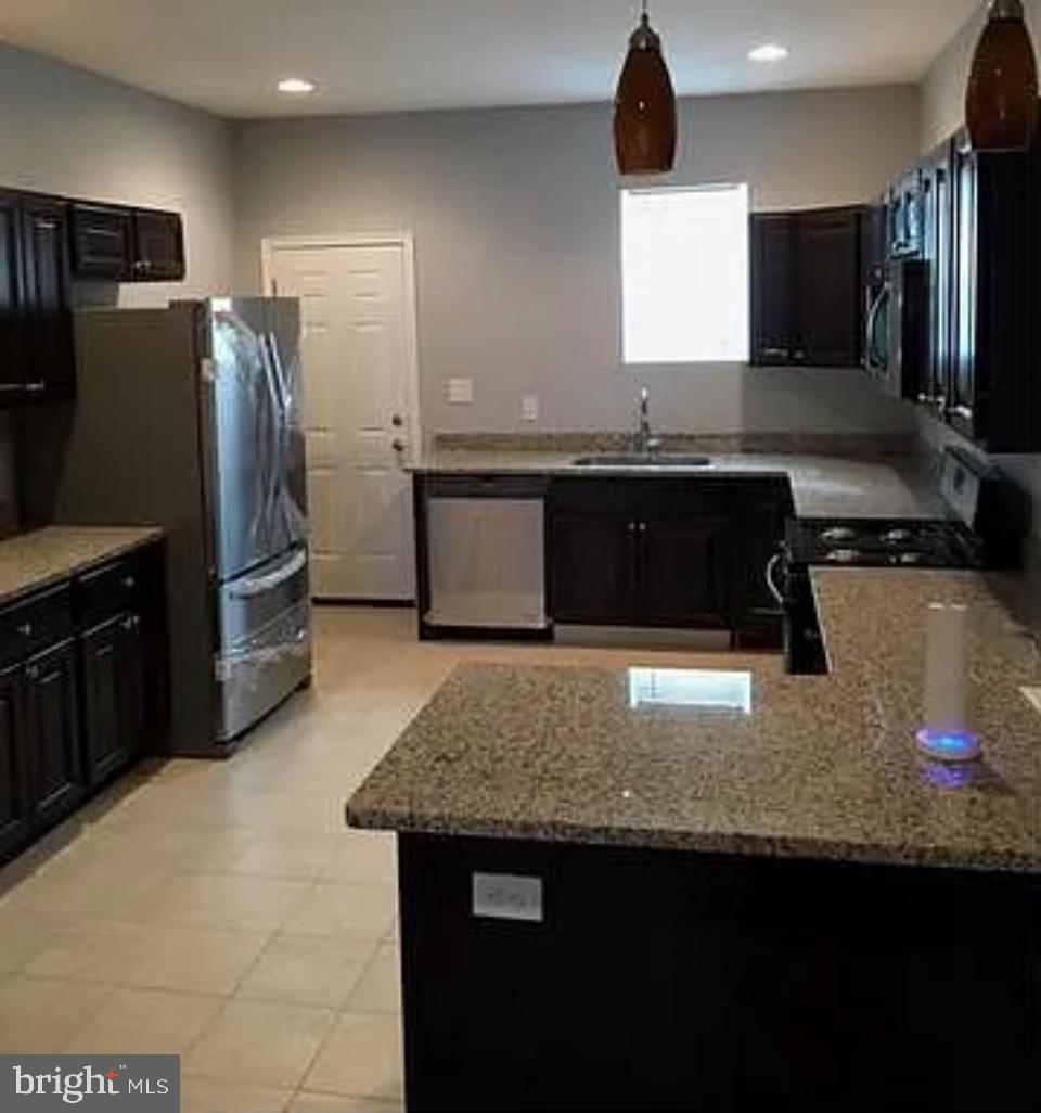 a kitchen with stainless steel appliances granite countertop a sink a stove and a refrigerator
