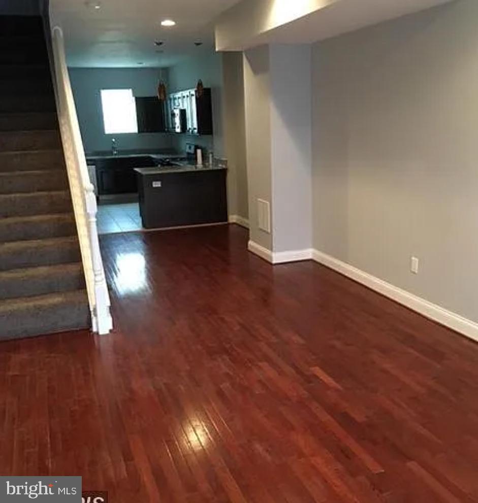 2023 West Lexington Street Baltimore, MD 21223 - Photo 9 of 10 a view of a living room with wooden floor and kitchen view