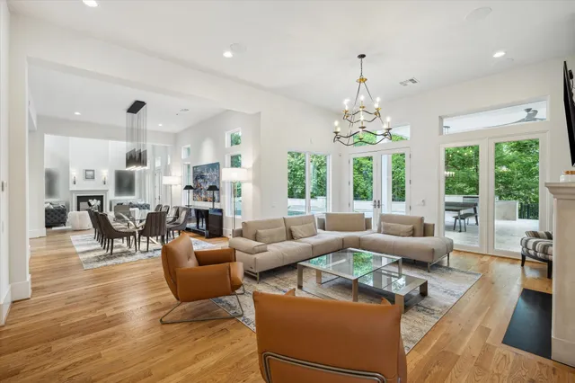 a living room with furniture a fireplace and a chandelier
