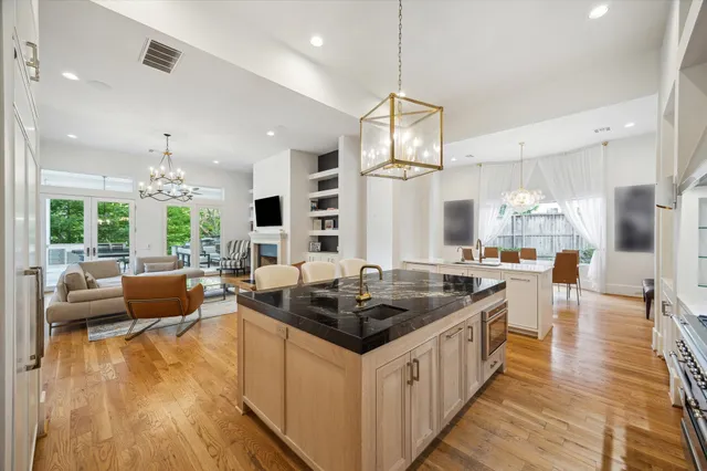 a kitchen with stainless steel appliances kitchen island granite countertop a stove and white cabinets