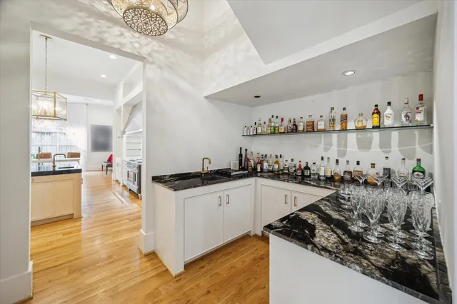 a kitchen that has a lot of cabinets a sink and wooden floor