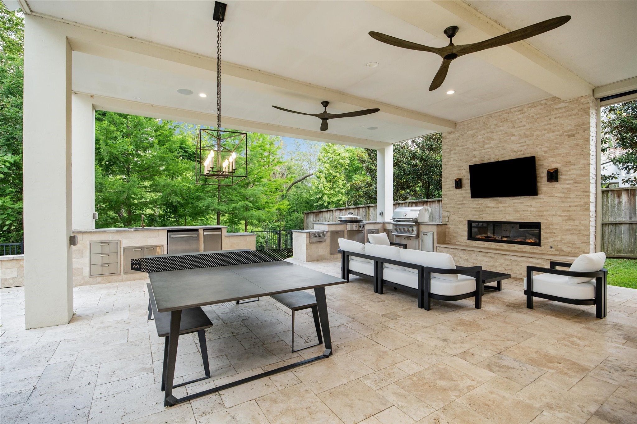 22 East Shady Lane, Unit E Houston, TX 77063 - Photo 4 of 50 Indulge in outdoor luxury at with this exquisite covered patio. Featuring a cozy fireplace and a state-of-the-art stainless steel grill with ample counter space, this space is perfect for entertaining.