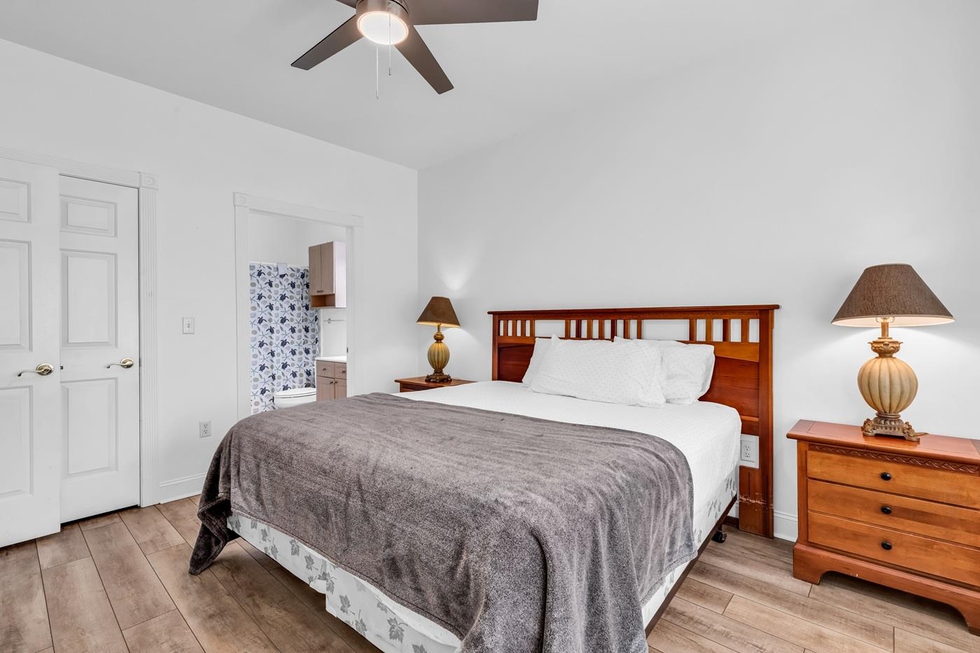 4801 Luster Leaf Circle, Unit 104 Myrtle Beach, SC 29577 - Photo 21 of 37 Bedroom with ensuite bathroom, light wood-style flooring, and a ceiling fan