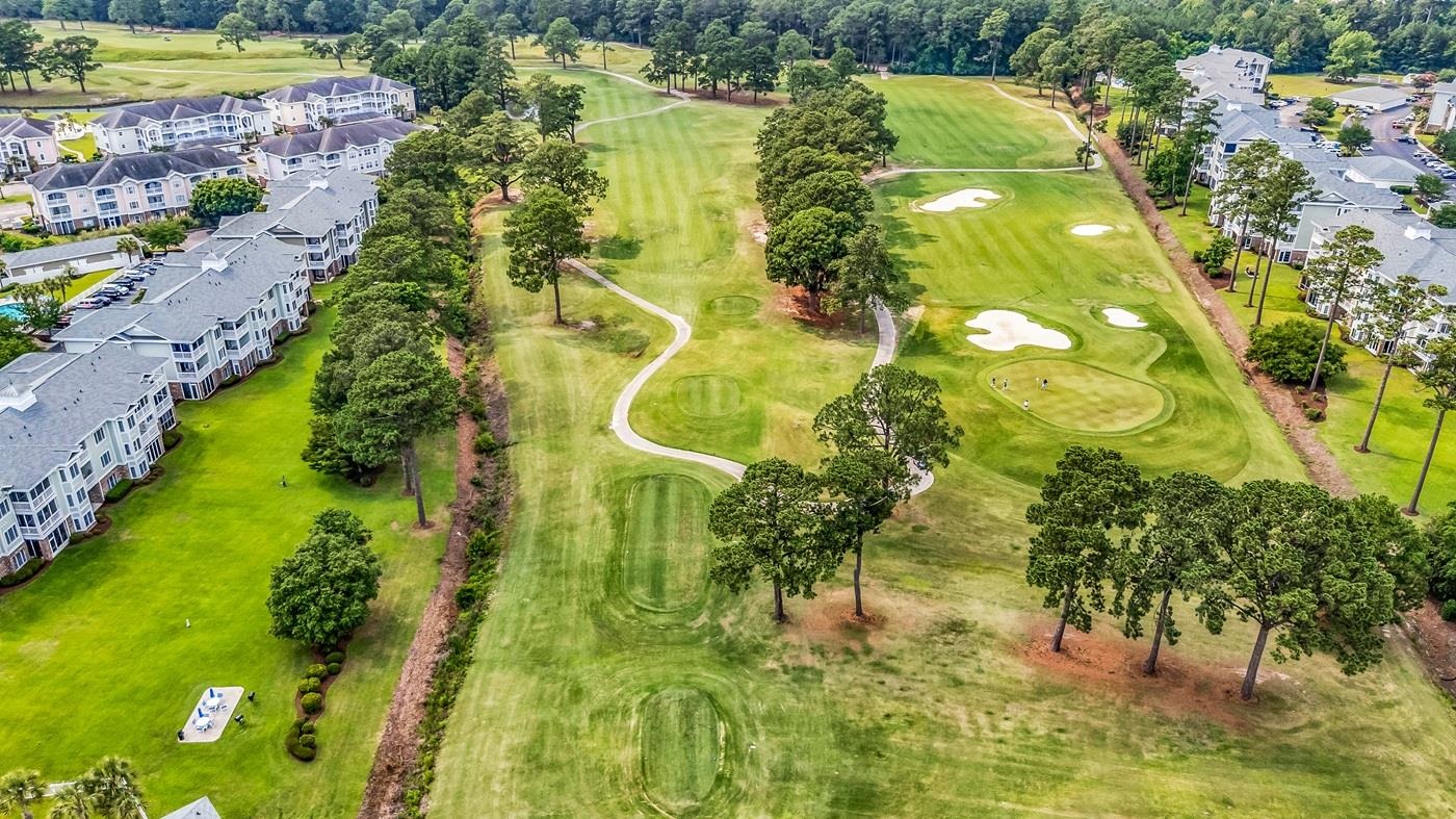 4801 Luster Leaf Circle, Unit 104 Myrtle Beach, SC 29577 - Photo 32 of 37 Aerial view of property's location featuring a local golf course and a tree filled landscape