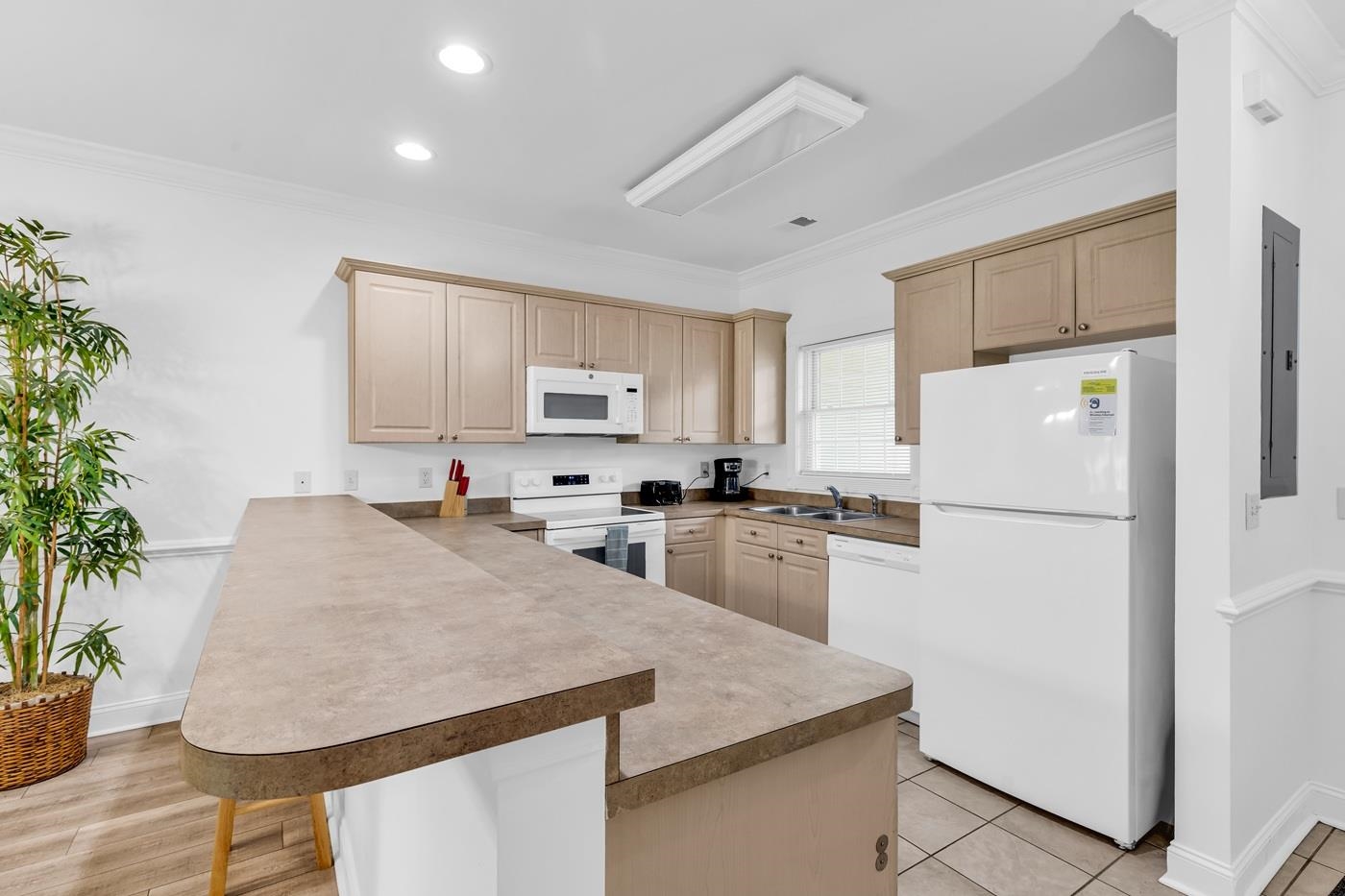 4801 Luster Leaf Circle, Unit 104 Myrtle Beach, SC 29577 - Photo 4 of 37 Kitchen featuring white appliances, a breakfast bar, ornamental molding, a peninsula, and recessed lighting