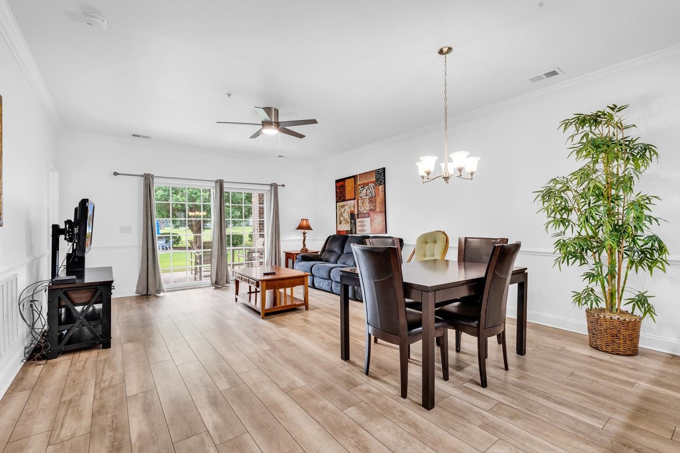 4801 Luster Leaf Circle, Unit 104 Myrtle Beach, SC 29577 - Photo 5 of 37 Dining space with a ceiling fan, light wood-style flooring, a chandelier, and crown molding