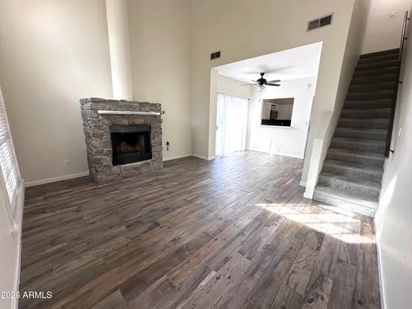 a view of a livingroom with wooden floor and staircase