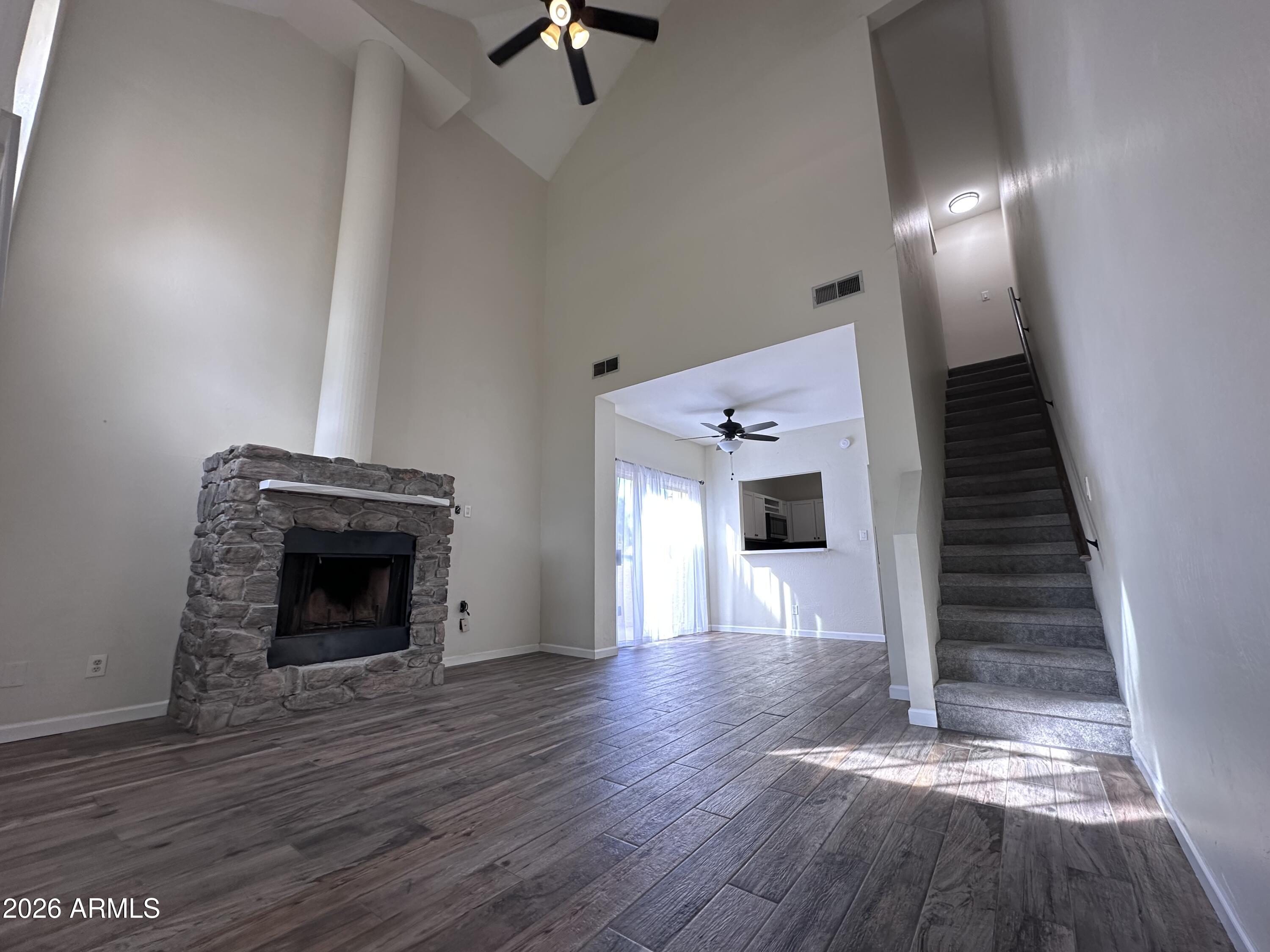 1126 West Elliot Road, Unit 1061 Chandler, AZ 85224 - Photo 2 of 24 a view of empty room with wooden floor and fireplace
