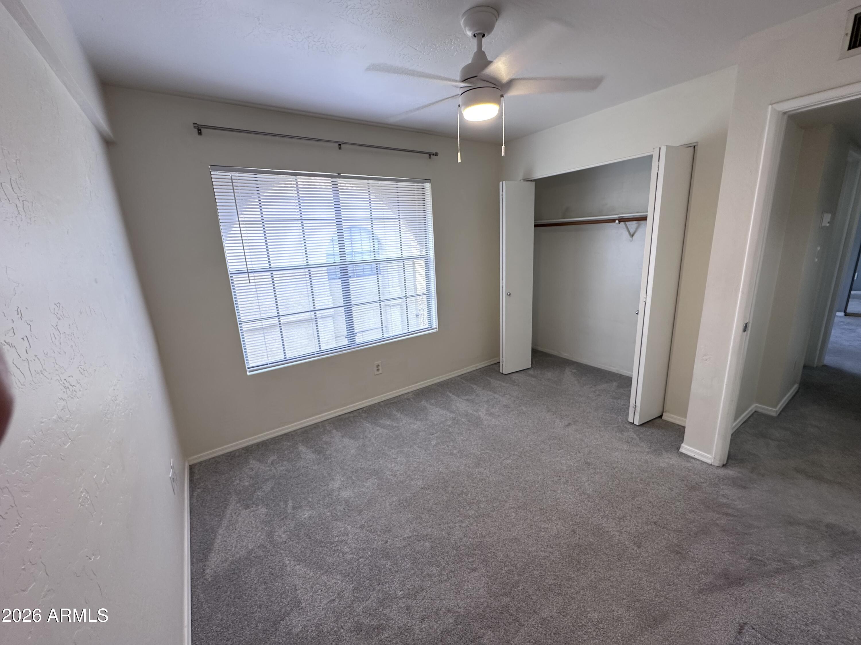 1126 West Elliot Road, Unit 1061 Chandler, AZ 85224 - Photo 10 of 24 an empty room with windows and fan