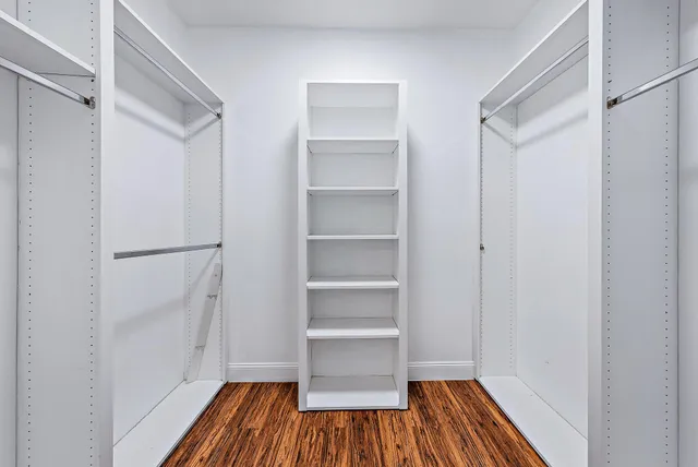 a view of walk in closet with wooden floor
