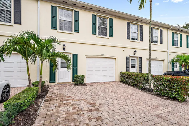 a front view of a house with a yard and potted plants