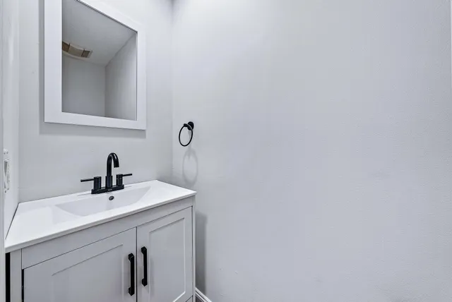 a bathroom with a sink a mirror and vanity