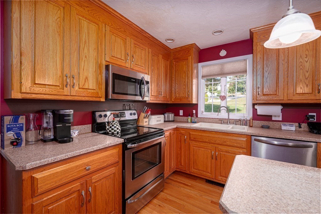 15 Fox Run Road, Unit 15 Blackstone, MA 01504 - Photo 4 of 22 a kitchen with granite countertop wooden cabinets stainless steel appliances a sink and a window